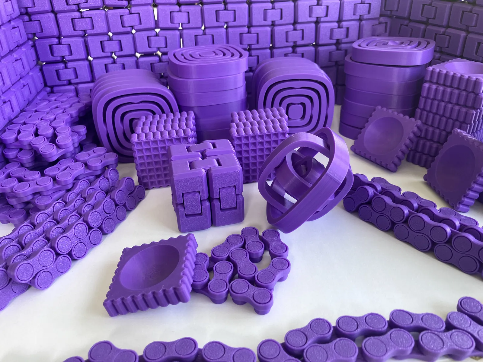 A bulk order in lavender: dozens of fidget chains, infinity cubes, spinners and worry stones, all in the same colour